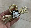 Pregadeira g metal laço cravejado e camélia esmaltada (12 peças)